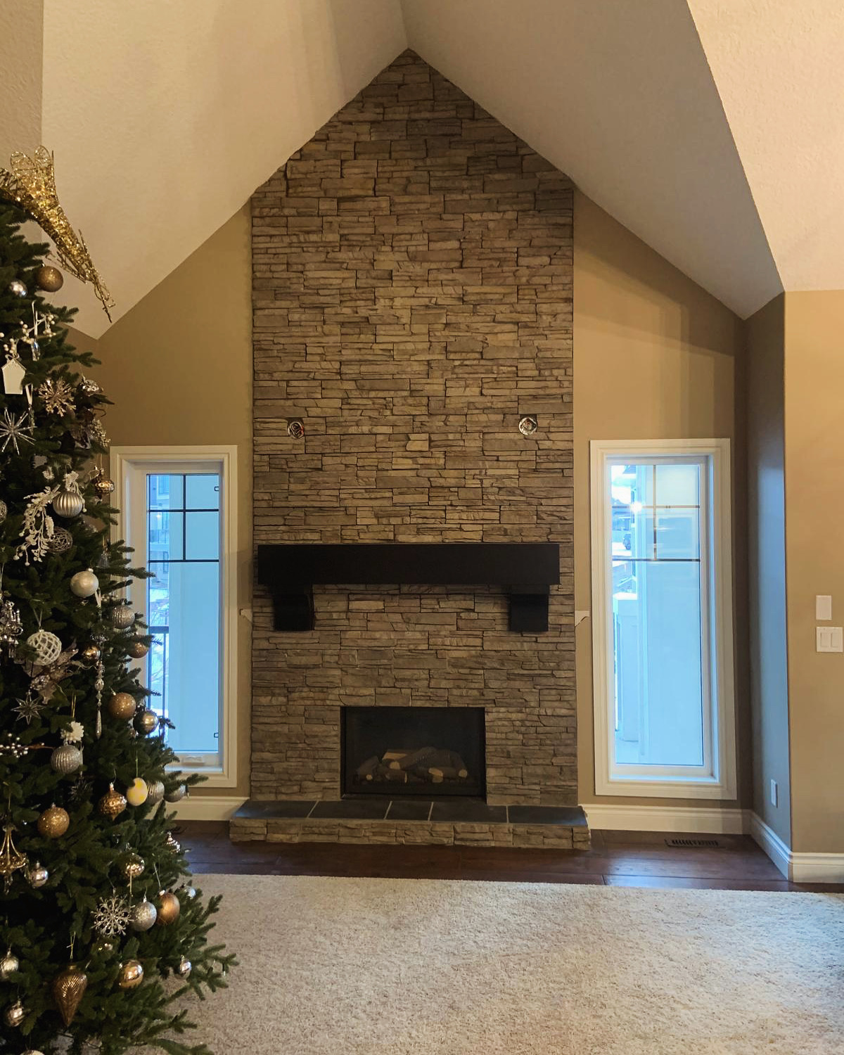 Floor-to-ceiling stacked-stone fireplace in a vaulted living room