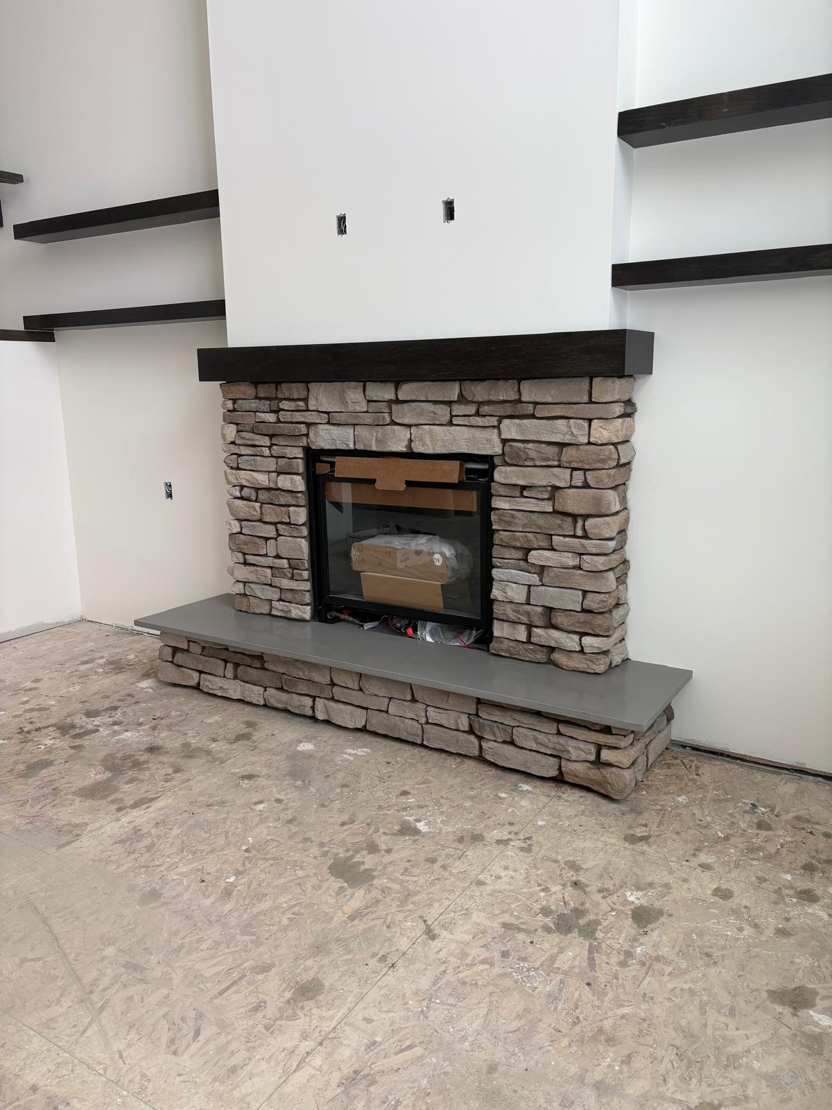 Custom indoor fireplace with timber mantel and stacked stone surround