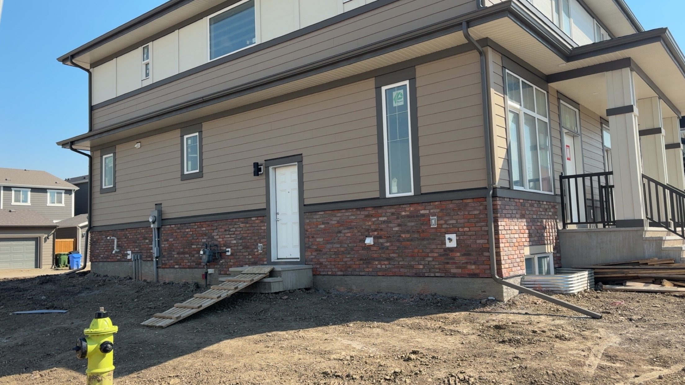 Brick base wrapping the side elevation of a residential home with siding above