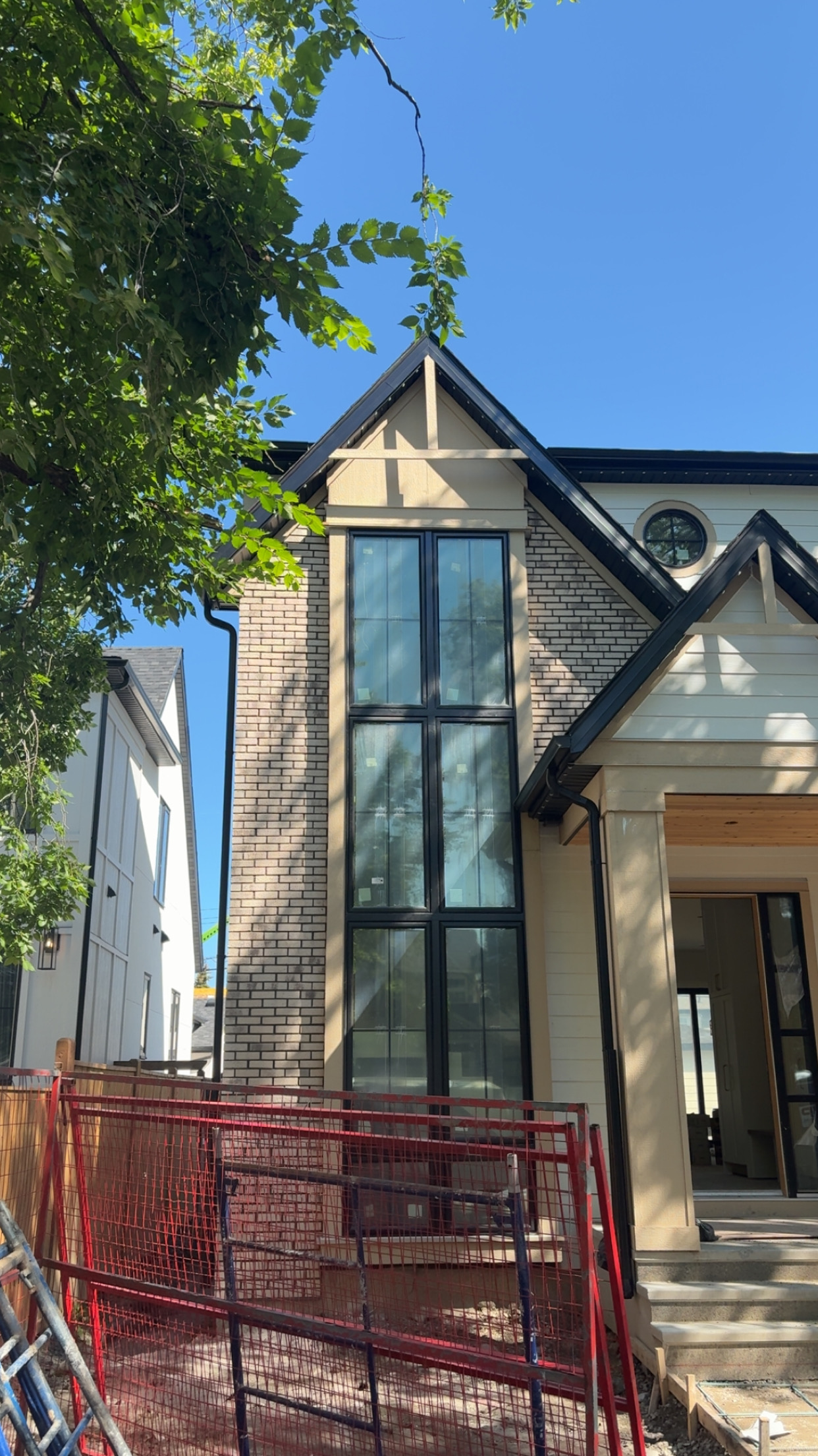 Custom two-storey home with peaked roof and brick veneer façade