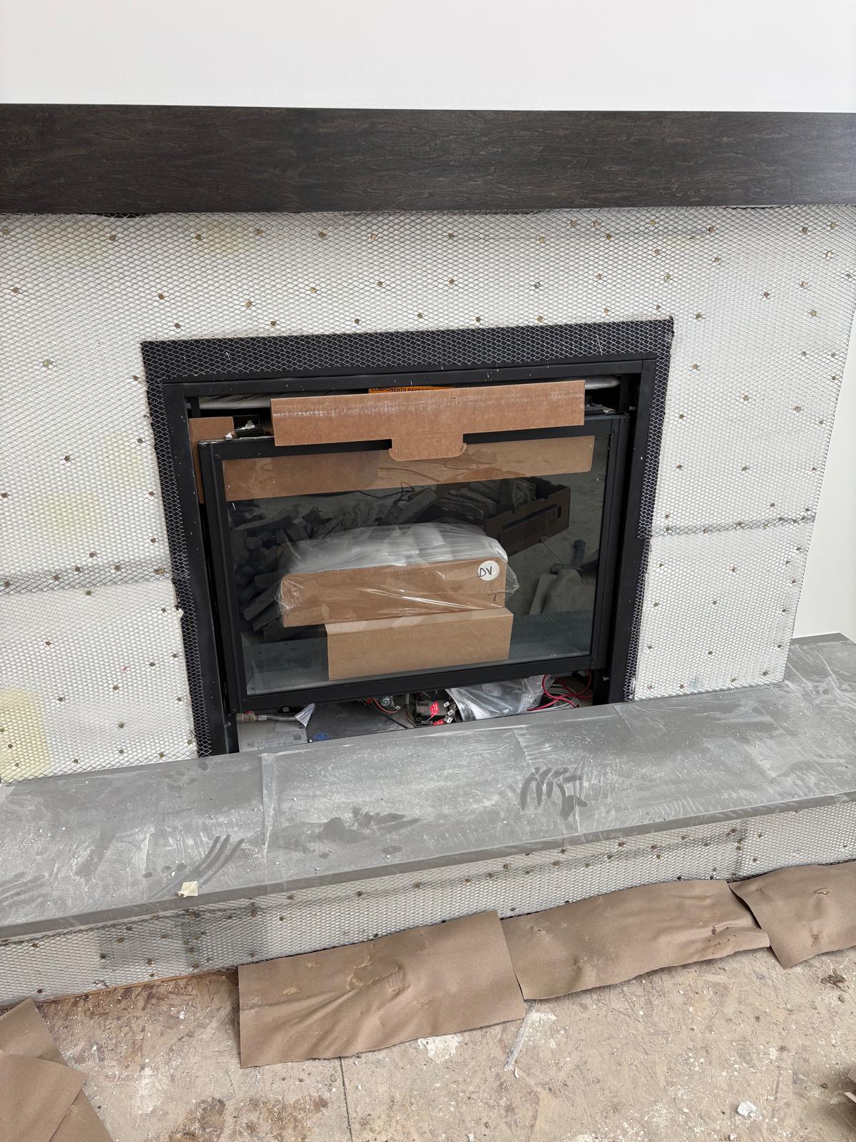 Interior fireplace insert and timber mantel during stone preparation